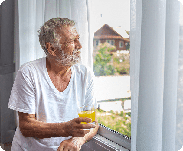 Elderly man looking out of a window